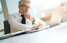 Un homme utilise un ordinateur portable.